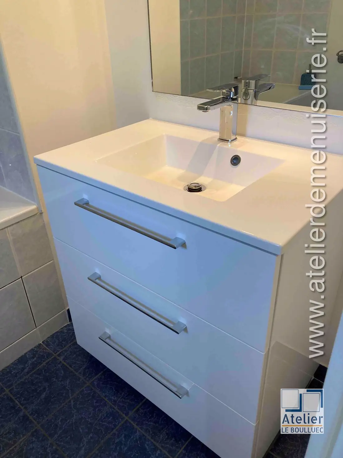 Meuble sous vasque laqué bleu clair à deux tiroirs, dans une salle de bain