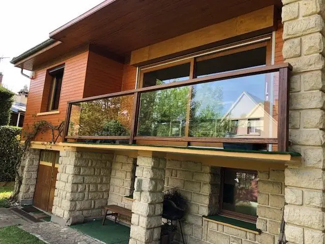 Garde-corps en bois et verre sur le balcon d’une maison contemporaine