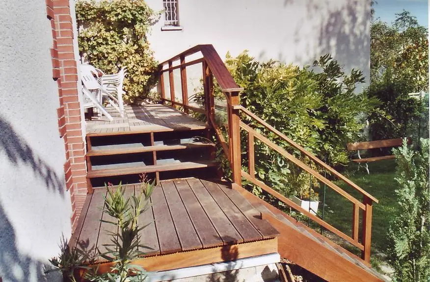 Terrasse et garde-corps en iroko devant une maison, vue d’ensemble