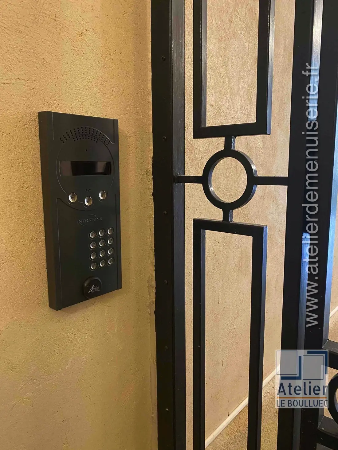 Platine d’interphone montée sur le montant d’une grille de sas en acier